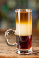Pride of Jamaica cocktail, shots on the bar. Blurred background.