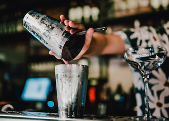 man bartender making cocktail in bar.