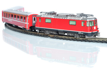 Scale toy model of red train isolated on white reflective background