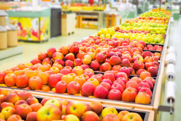 A large basket of ripe red apples in a light store. Abundance of delicious fruits in the supermarket