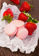 Fototapeta na wymiar macarons with strawberries. Macaroon with raspberries cookies on a wooden background