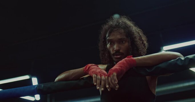 exhausted african fighter is resting after hard match, workout on boxing ring, portrait, 4K, Prores