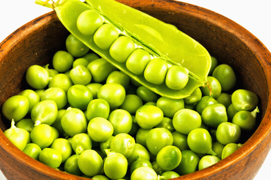 Fresh green peas in a clay cup