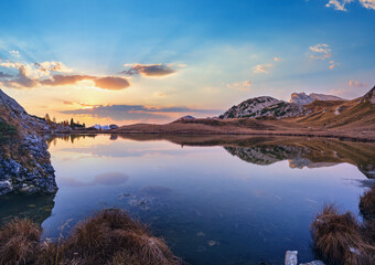 Early morning autumn alpine Dolomites mountain scene. Peaceful Valparola Path and Lake view, Belluno, Italy.