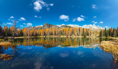Fototapeta premium Autumn alpine mountain lake near San Pellegrino Pass, Trentino, Dolomites Alps, Italy.