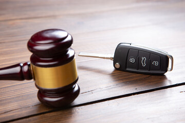 Car auction concept - gavel and car key on the wooden desk