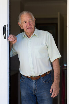 Senior gentleman looking out of doorway