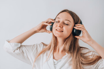 Pretty young woman girl on white wall background studio portrait. People emotions lifestyle concept. Mock up copy space. Listen music