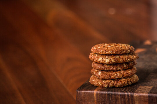 Stack of ANZAC biscuits on a wooden board