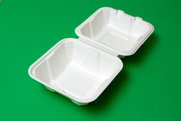 Open clean biodegradable bento box on green background. Selective focus. Images for articles about environmental friendliness, cakes.