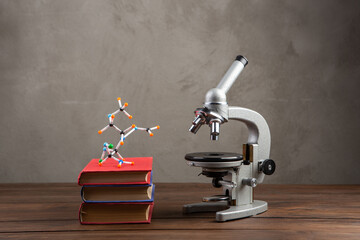 Back to school - books and microscope on the wooden desk in the auditorium, Education concept