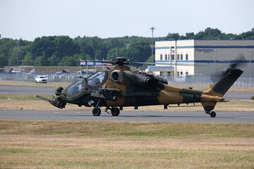 Thunderous Preparations: Intense Moments as an Attack Helicopter Gears Up for Takeoff