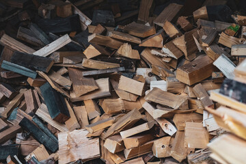 Pile of pieces of firewood. Many pieces of spruce trunk accumulated. Wood texture and carpentry industry. Logging and damage to forests.