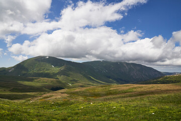 Obraz premium alpine meadows in the mountains with clouds on a sunny day