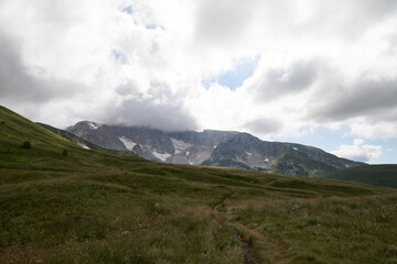 Obraz premium alpine meadows in the mountains with clouds on a sunny day