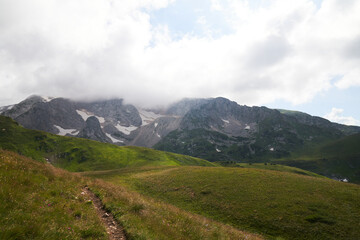 Fototapeta premium alpine meadows in the mountains with clouds on a sunny day