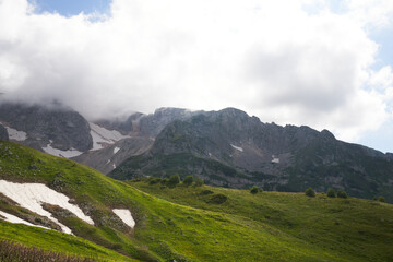 Obraz premium alpine meadows in the mountains with clouds on a sunny day