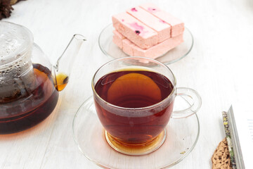 Pink fruit marshmallow with cranberries, teapot and cup of black tea