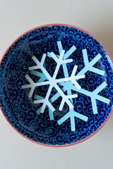 paper snowflakes in a blue bowl