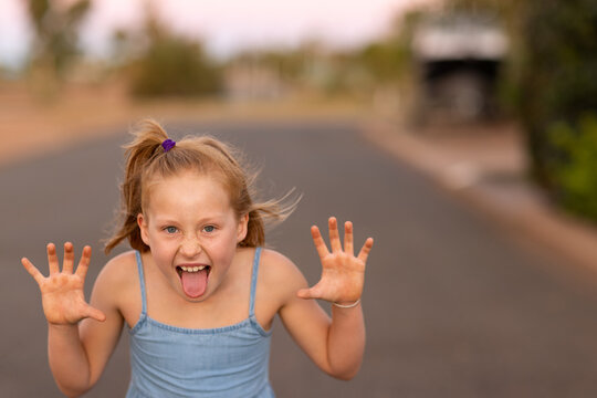 girl outside making scary face with hands like claws