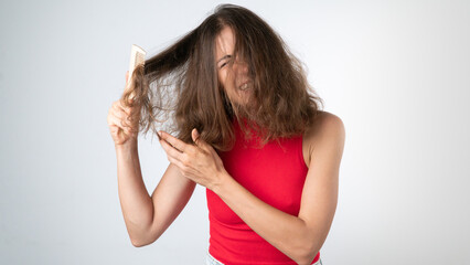 It hurts a woman when combing naughty, tangled hair - pulling out a comb and pulling her hair