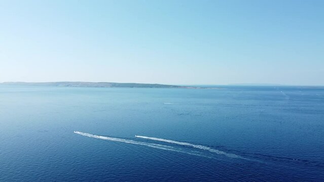 speedboat leaves a white trail on the calm surface of the Adriatic Sea, Croatia, Rab island archipelago, summer
