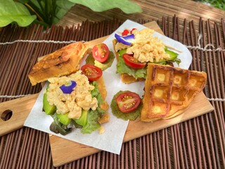 Fried egg with avocado waffle sandwiches