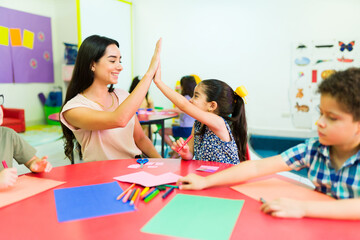 Excited girl celebrating with her happy preschool teacher