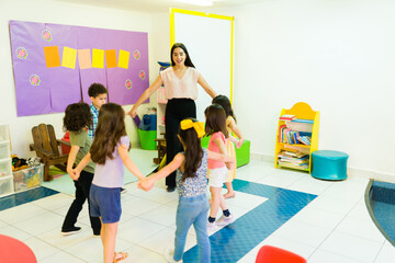 Teacher and kindergarten students playing a fun game at school