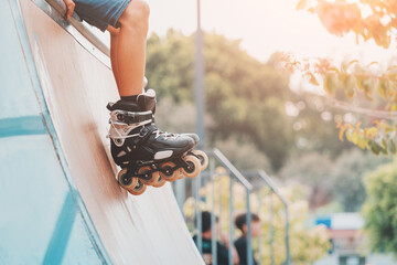 Close-up of the legs of a roller skater performing tricks and just riding on the ramp in urban...