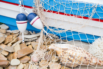 Fishing nets, floats, corals and shells on the sandy shore.
