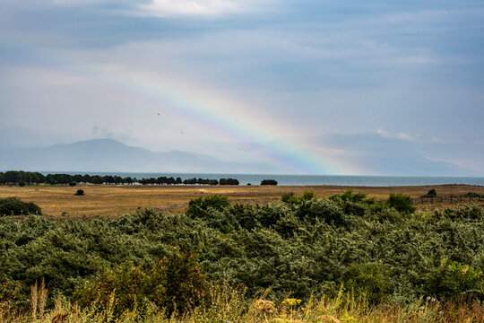 rainbow after the rain against the backdrop of the landscape of mountains and lake Sevan in Armenia