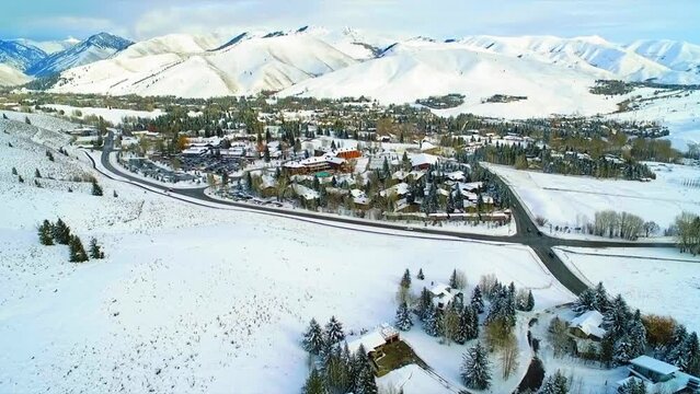 Aerial Forward Shot Of Resorts In Town By Snow Covered Mountains - Sun Valley, Idaho