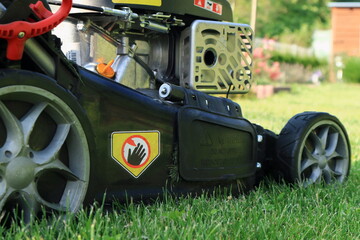 mowing the lawn in the garden with a petrol lawn mower
koszenie trawnika w ogrodzie kosiarką spalinową