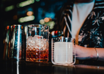 woman hand bartender making negroni cocktail in bar