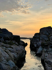 kanał dopływający z morza pomiędzy skałami o zachodzie słońca - obrazy, fototapety, plakaty