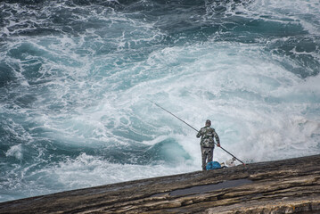 A man fishing off the Cantabrian coast in the Basque Country. San Sebastian, Spain