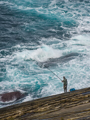 A man fishing off the Cantabrian coast in the Basque Country. San Sebastian, Spain