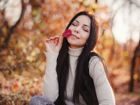 Beautiful young brunette spends her free time in the autumn forest