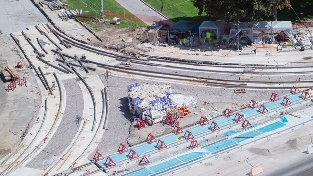 Repair works on the street timelapse. Laying of new tram rails on a city street. Installation of new modern railway rails for trams. Aerial top view. Reconstruction of tram tracks on intersection