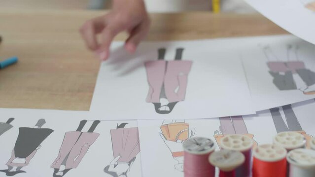 Close Up Of Clothes Drawing Pictures Being Rearranged On The Table In The Studio
