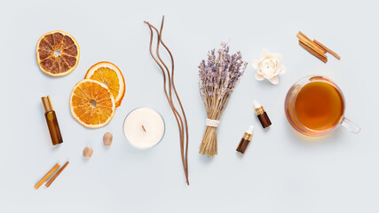 Relax at home. Cup of herbal tea, aroma candle, sticks, lavender flowers, dry orange slices and natural oils on a blue background. Insomnia or depression treatment. Self care and me time concept