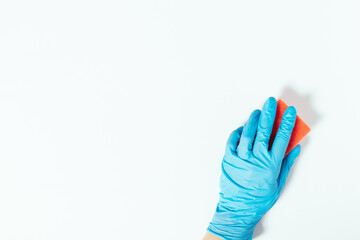 Hand in blue glove cleaning surface with sponge