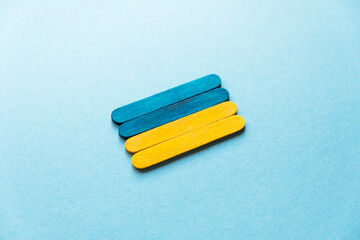 Ukraine flag made of wooden sticks on a blue background