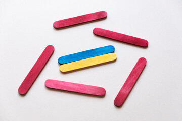 War in Ukraine. political conflict. Flag of ukraine made of wooden sticks among red sticks. Danger. Country defense. Threat to Ukraine