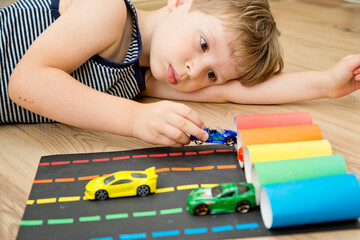 Speedway playground. 5 minute crafts. DIY toy. Boy sorting machines by color. Montessori concept,...
