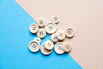 wooden buttons on a blue and beige background. Material for needlework. Sewing. Buttons for clothes