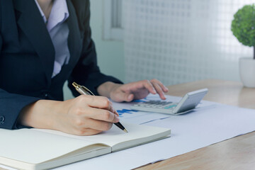 Business woman Write note and  analyzing data from market report.Business Financial Concept