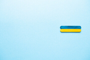 Blue and yellow wooden sticks. Flag of Ukraine on a blue background, free space