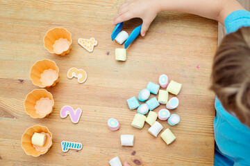 Fun at home. DIY game for children. Idea for mommy. Marshmallows and cupcake molds. Put as many sweets as the number by the cup. Learning trough the game.